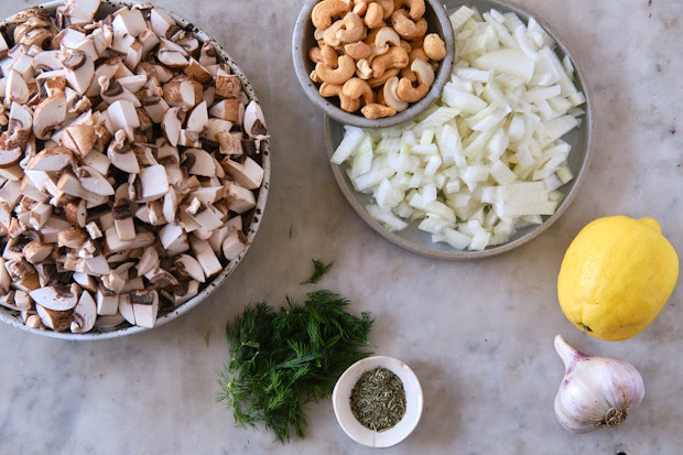 ingredients for cooking cream of mushroom soup including onions, mushrooms, herbs, and garlic 