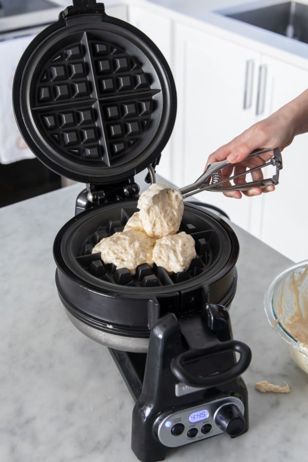 Spooning about 1 cup of waffle batter onto pre-heated waffle iron.